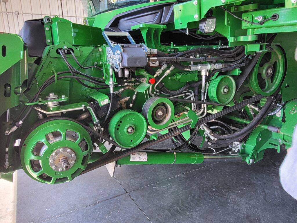 Exposed belts, pulleys and hydraulic lines during X9 feederhouse removal